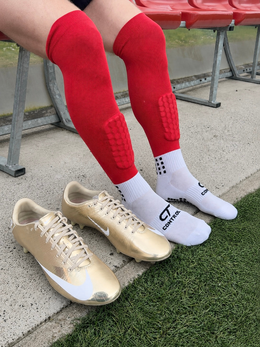 Person wearing Control Sport 3 in 1 Football socks in red with gold boots. All in 1 design 