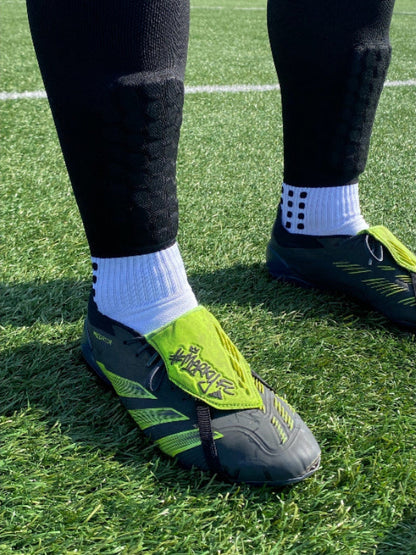 Person wearing black 3 in 1 sock with black and green boots 